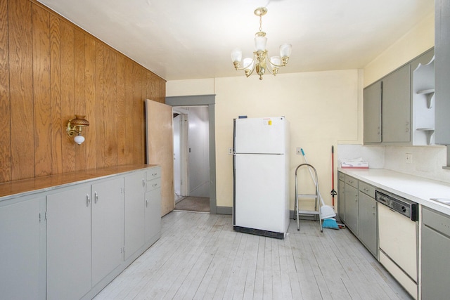 kitchen featuring hanging light fixtures, white appliances, light hardwood / wood-style flooring, gray cabinets, and a notable chandelier