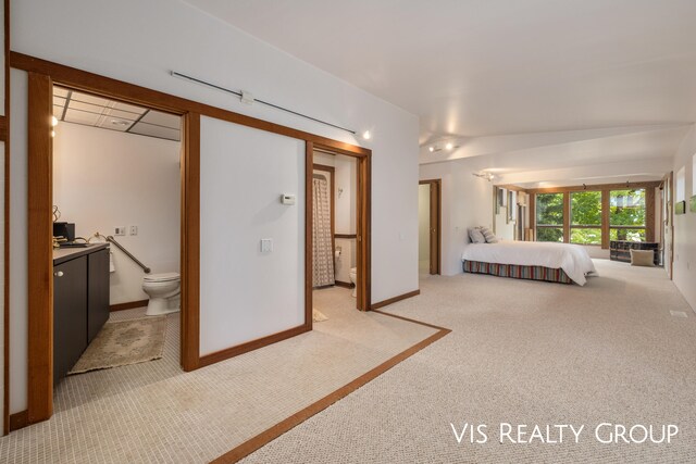 unfurnished bedroom with light colored carpet and ensuite bath