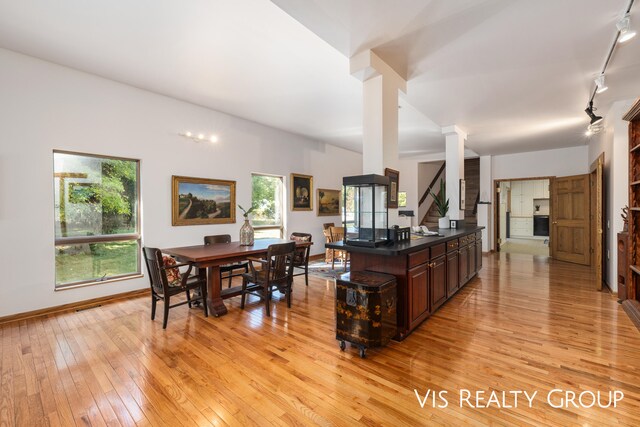 kitchen featuring rail lighting, dark brown cabinets, light hardwood / wood-style flooring, and a wealth of natural light