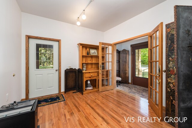 interior space with french doors, light wood-type flooring, and track lighting