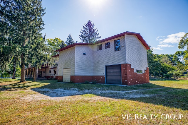 view of home's exterior with a garage and a yard