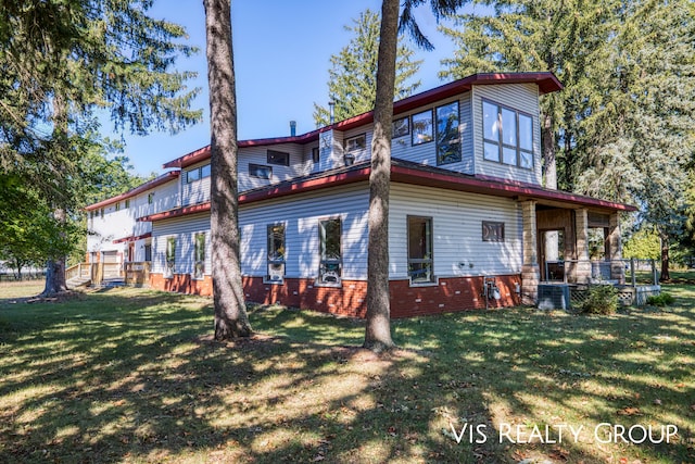 back of house featuring a lawn and central AC