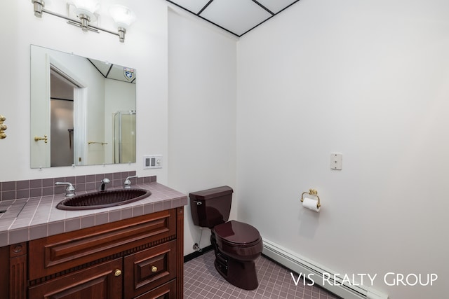 bathroom with vanity, walk in shower, a baseboard radiator, toilet, and tile patterned floors