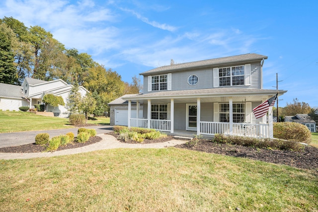 view of front of home with a garage, a porch, and a front yard