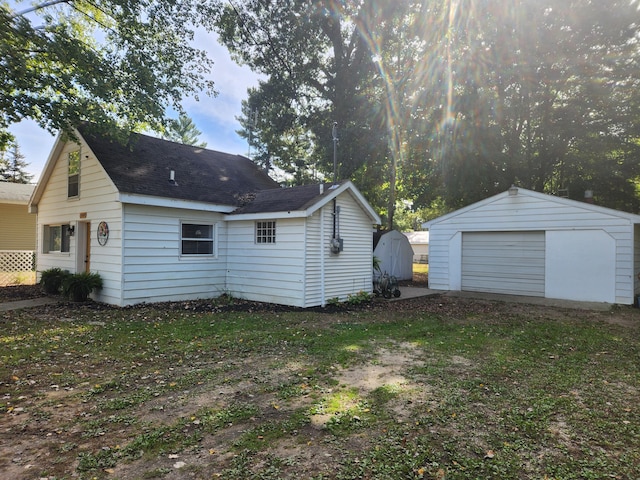 back of property featuring an outbuilding and a garage