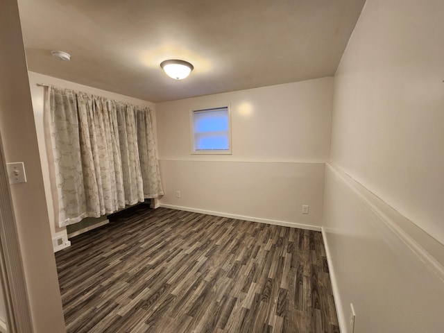 unfurnished room with dark hardwood / wood-style floors