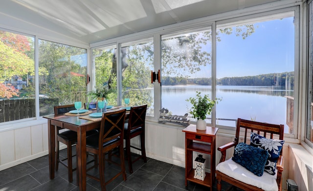 sunroom / solarium featuring a water view