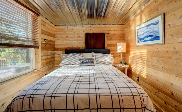 bedroom featuring wooden walls and wooden ceiling