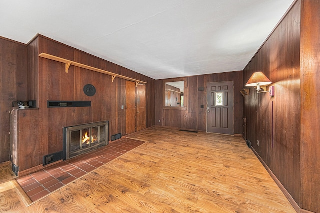 unfurnished living room featuring wooden walls and hardwood / wood-style floors