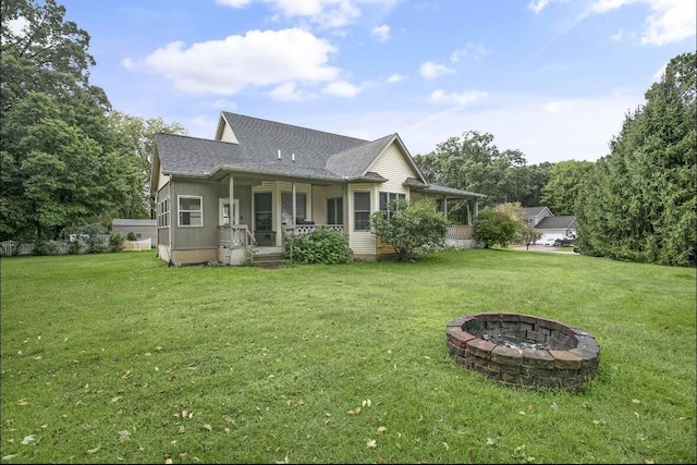 back of house with a lawn, a porch, and a fire pit