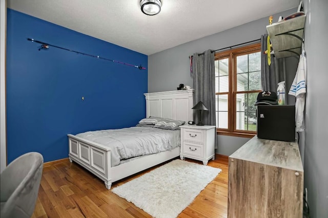 bedroom featuring a textured ceiling and hardwood / wood-style flooring