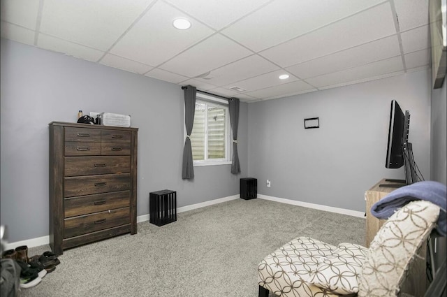 living area featuring light carpet and a drop ceiling