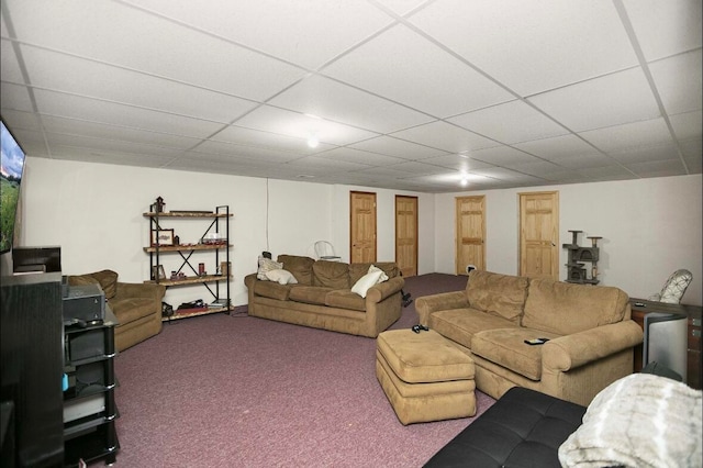 living room featuring a paneled ceiling and carpet