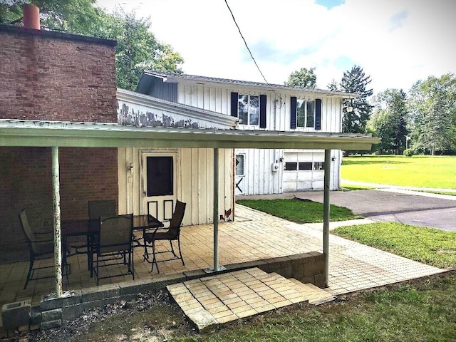 back of property featuring a lawn and a garage