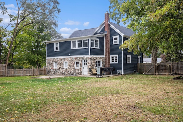 rear view of property featuring a yard and a patio area