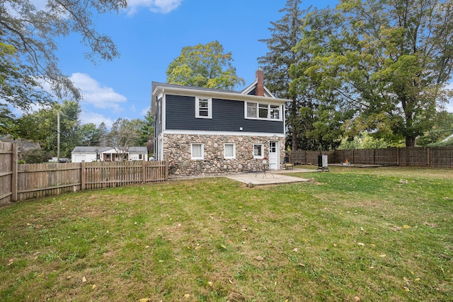 rear view of property with a yard and a patio area