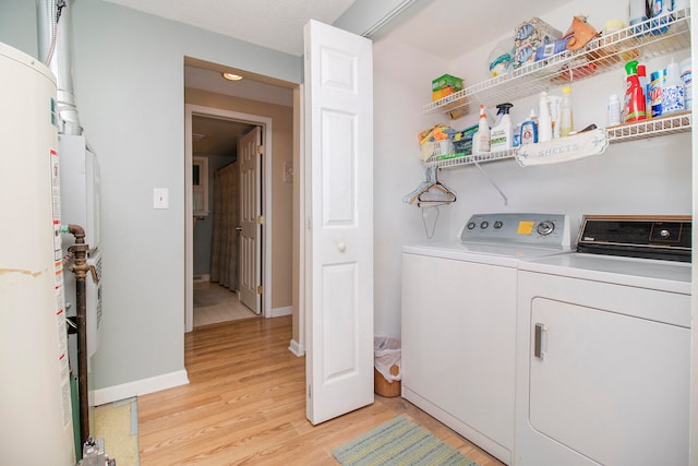 clothes washing area with light wood-type flooring and washing machine and clothes dryer