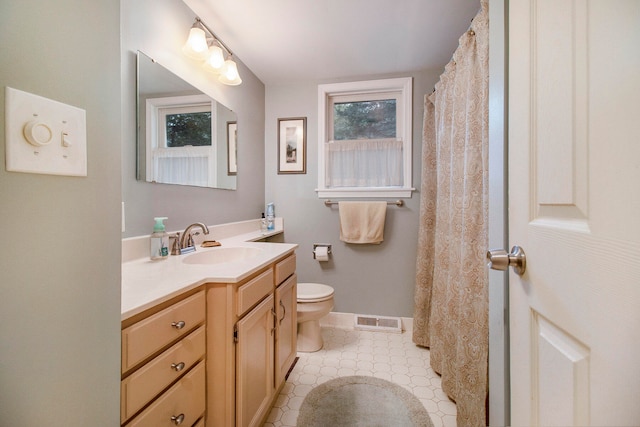 bathroom featuring tile patterned flooring, vanity, and toilet