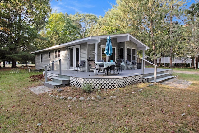 back of property with a lawn and a wooden deck