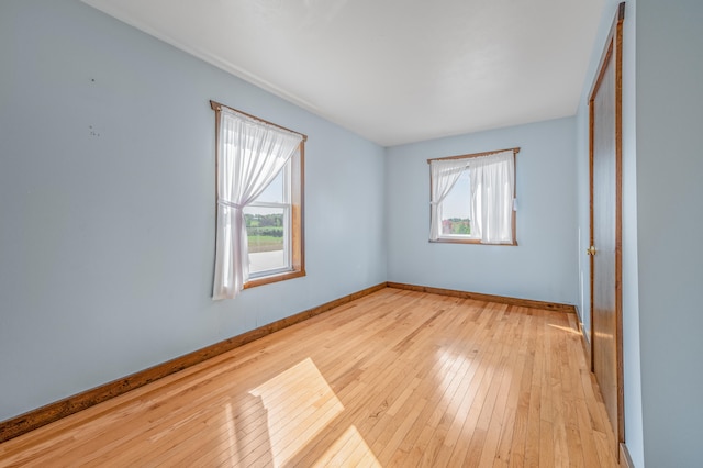 unfurnished room with light wood-type flooring