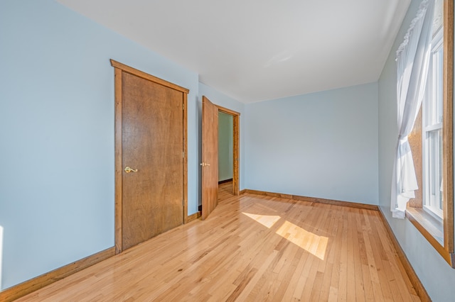 unfurnished bedroom with light hardwood / wood-style flooring and multiple windows