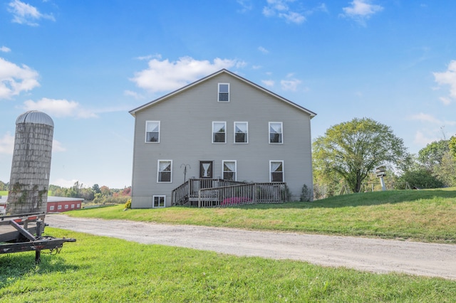 back of house with a deck and a yard