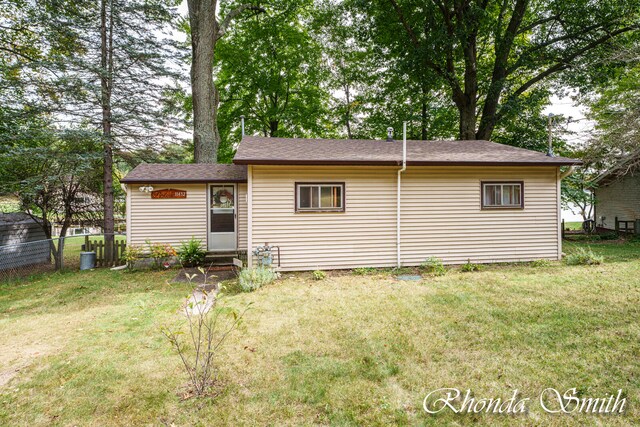 back of property featuring a lawn