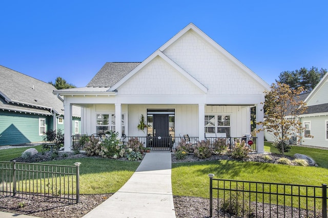 modern inspired farmhouse featuring a porch, board and batten siding, a front yard, and fence