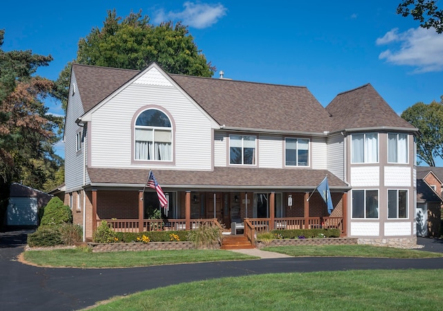 view of front of home with covered porch and a front lawn