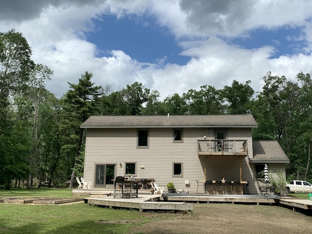 back of house with a lawn, a balcony, and a deck