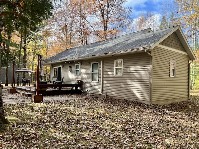 rear view of house featuring a wooden deck