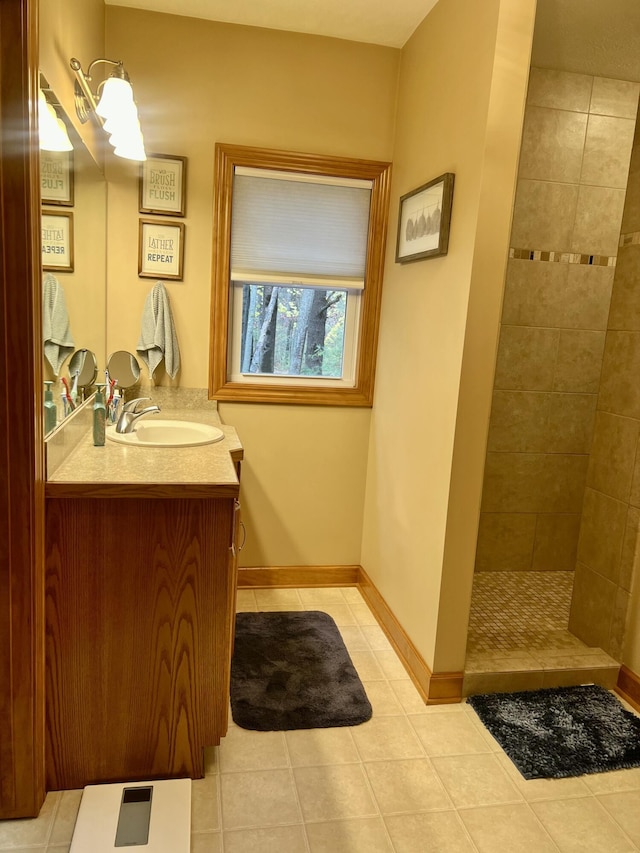 bathroom with tile patterned floors, vanity, and a tile shower