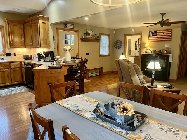 dining area with ceiling fan, light hardwood / wood-style floors, and a baseboard radiator