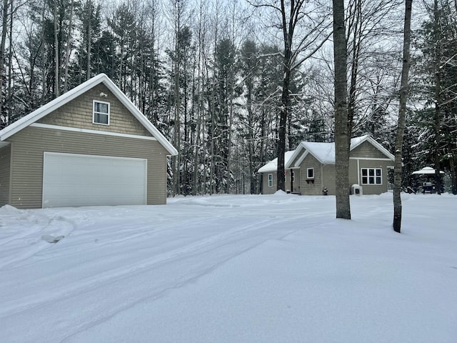 view of snow covered exterior with a garage