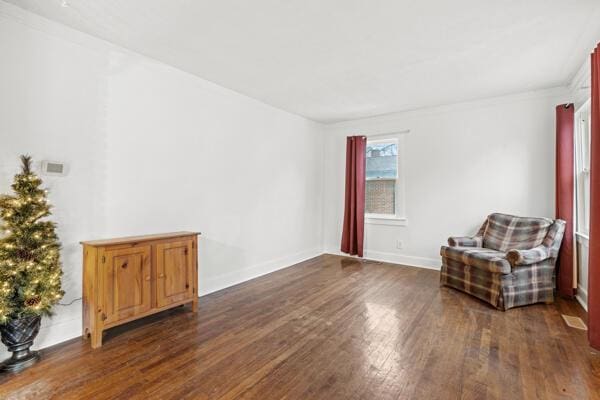 sitting room featuring crown molding and dark wood-type flooring