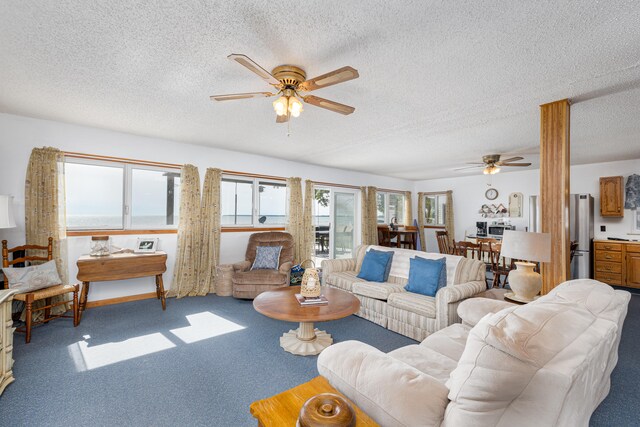 carpeted living room featuring ceiling fan and a textured ceiling