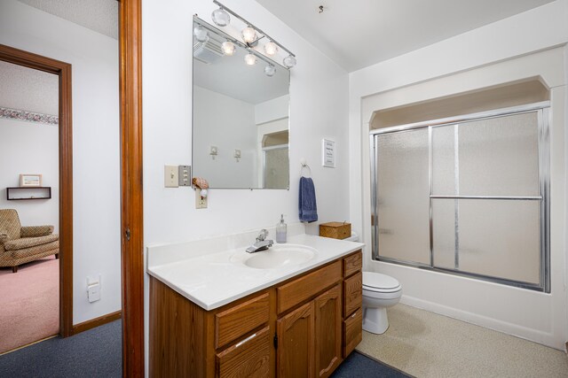 full bathroom with enclosed tub / shower combo, vanity, and toilet