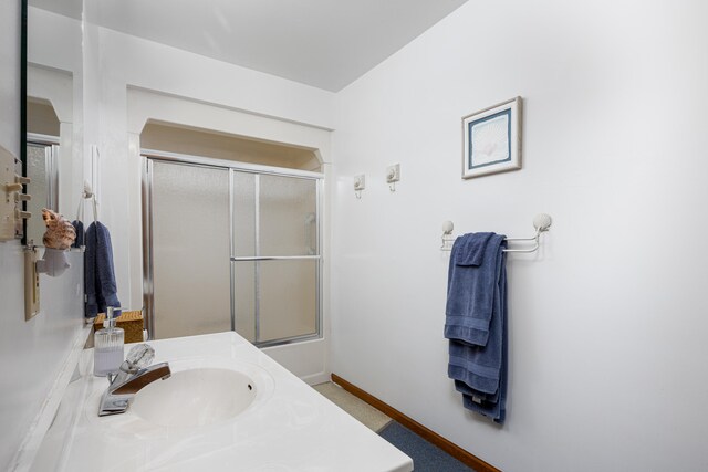 bathroom featuring vanity and a shower with shower door