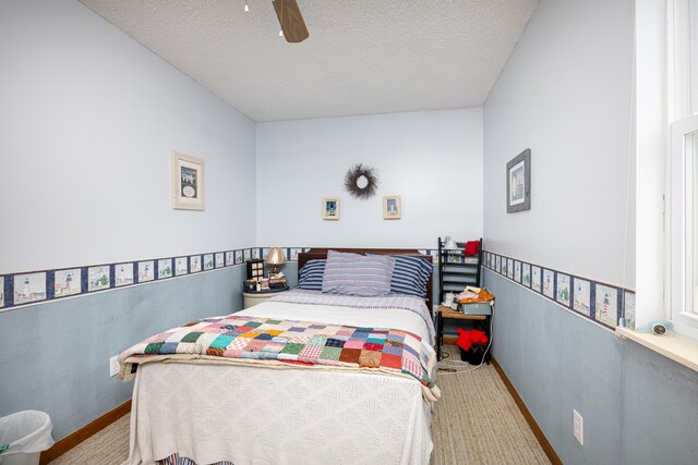 bedroom with ceiling fan and a textured ceiling