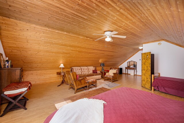 interior space featuring ceiling fan, lofted ceiling, wood ceiling, wooden walls, and light hardwood / wood-style floors