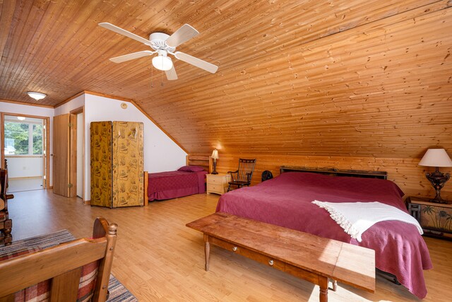 bedroom with wood ceiling, vaulted ceiling, wood walls, ceiling fan, and light hardwood / wood-style flooring