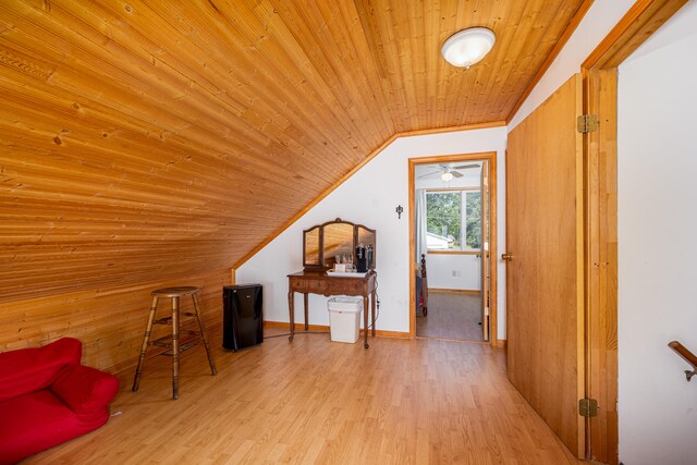 additional living space with lofted ceiling, wood walls, light hardwood / wood-style floors, and wood ceiling