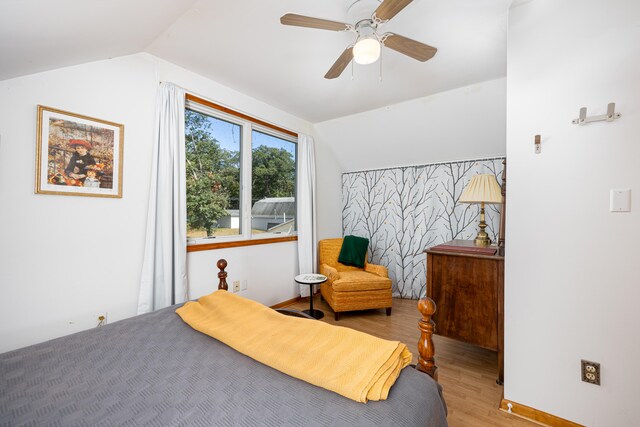 bedroom featuring ceiling fan, light wood-type flooring, and vaulted ceiling