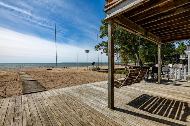 wooden terrace with a water view and a beach view