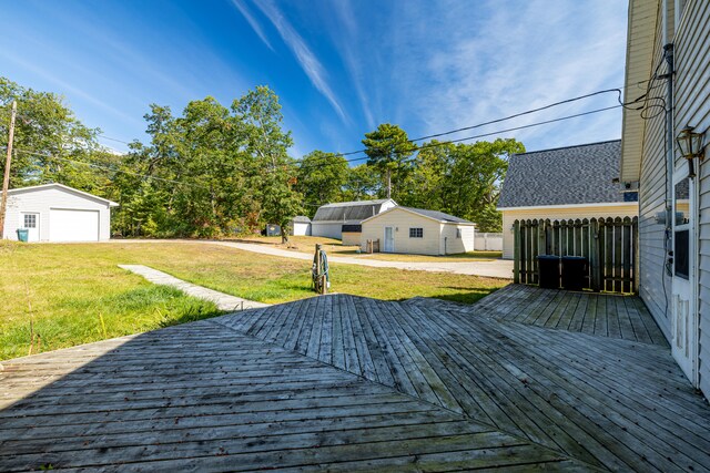 deck featuring an outdoor structure, a garage, and a yard