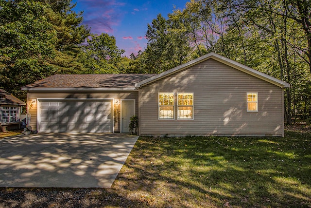 ranch-style house with a yard and a garage