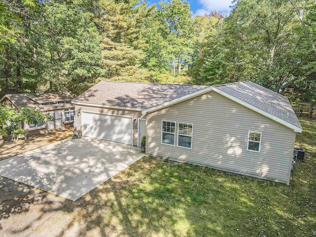 view of front of house featuring a front lawn, cooling unit, and a garage