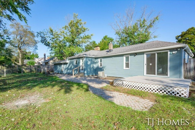 back of property featuring a yard, central AC, and a wooden deck