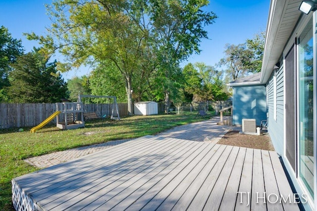 deck with a storage unit, a playground, and a lawn