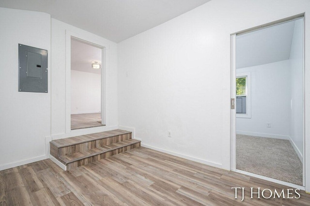 interior space with electric panel and light hardwood / wood-style flooring